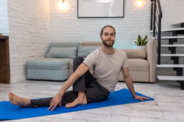Evde Yoga Yapan Çekici Bir Adam Yoga Minderinde Vücut Esnetiyor — Stok fotoğraf