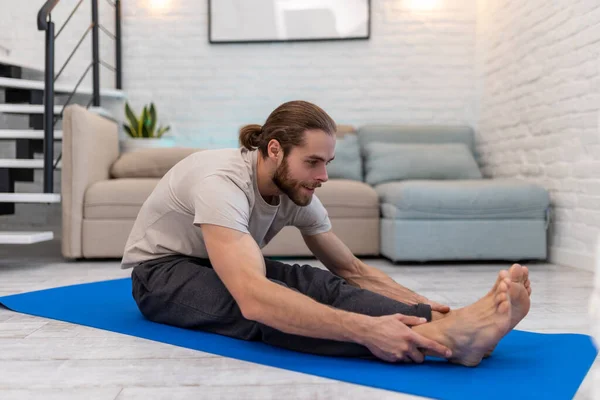 Evde Yoga Yapan Genç Bir Adam Yoga Minderinde Vücut Esnetiyor — Stok fotoğraf