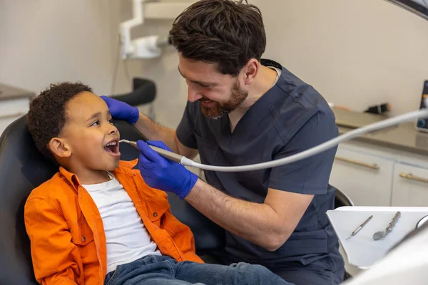 Στην Οδοντιατρική Άντρας Οδοντίατρος Που Δουλεύει Σκουρόχρωμο Αγόρι — Φωτογραφία Αρχείου