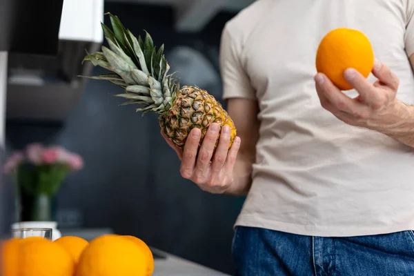 Unrecognizable Man Holding Orange Pineapple Standing Kitchen — Stock Photo, Image
