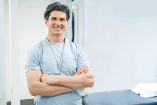 Arzt Dunkelhaarige Männliche Physiotherapeutin Wirkt Selbstbewusst Und Lächelnd — Stockfoto