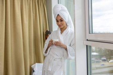 Duştan sonra. Duştan sonra bornozlu hoş bir genç bayan.