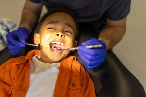 Dentystów Dentysta Badający Jamę Ustną Małego Chłopca Ciemnej Skórze — Zdjęcie stockowe