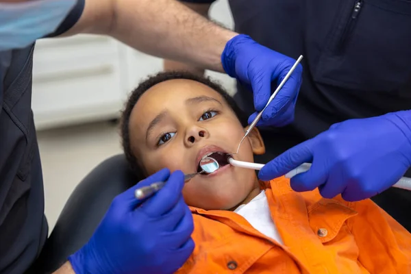 Odontología Dentista Asistente Trabajando Con Chico Piel Oscura —  Fotos de Stock