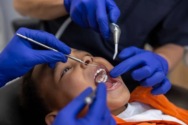 Stomatologii Dentysta Jego Asystent Pracują Ciemnoskórym Chłopcem — Zdjęcie stockowe