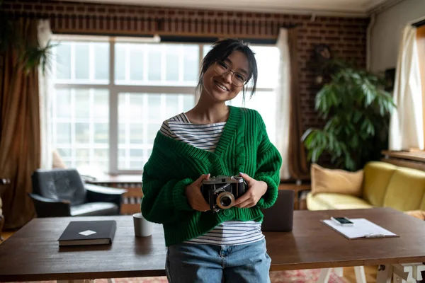 年轻的摄影师穿着绿衬衫手里拿着相机的女孩 — 图库照片