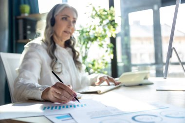 Proje üzerinde çalış. Bilgisayardaki yakışıklı, olgun iş kadını meşgul görünüyor.