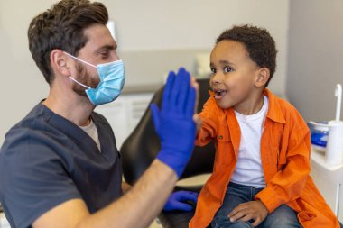 Çak bakalım. Doktor ve küçük hasta beşlik çakıyor ve memnun görünüyorlar.
