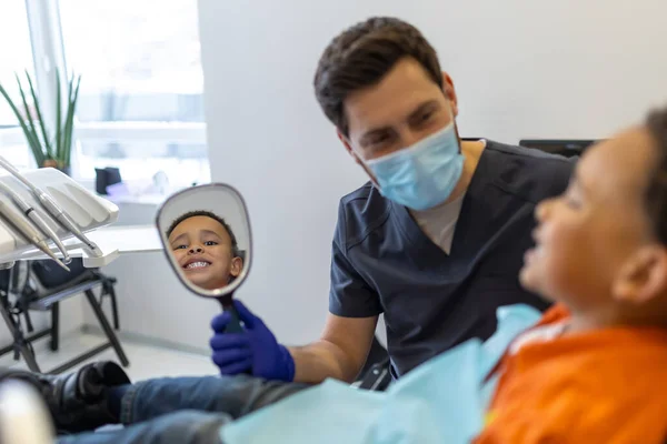 歯医者だ セッション前に歯科医と話す暗い肌の少年 — ストック写真