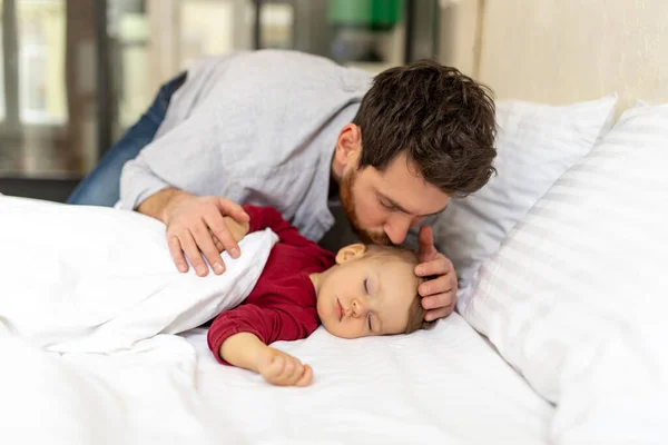 布鲁内特长着胡子的父亲温柔地亲吻熟睡的婴儿 — 图库照片