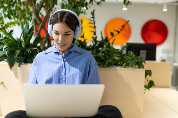 Mosolygó Elégedett Fiatal Fülhallgatóban Ült Coworking Térben Bámulja Laptop Képernyőn — Stock Fotó