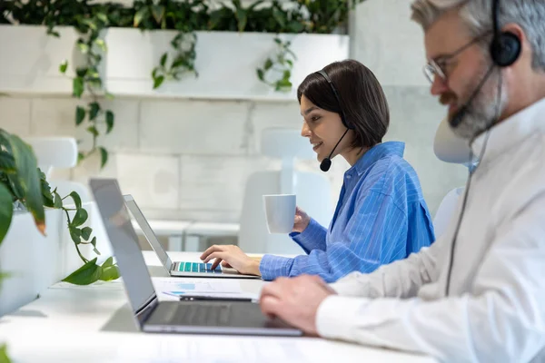 책상에 휴대용 컴퓨터를 사용하는 사무직 근로자들의 — 스톡 사진