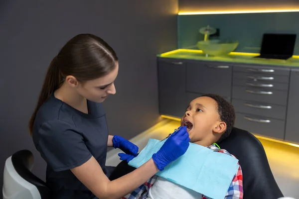Der Zahnmedizin Ärztin Untersucht Dunkelhäutigen Jungen — Stockfoto