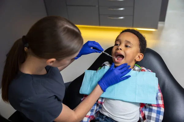 歯医者だ 女性医師チェックアップ暗い肌の男の子 — ストック写真