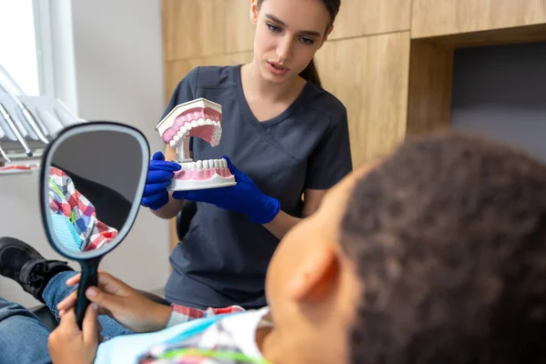 Diş Hekimliğinde Kadın Doktor Ona Çene Maketi Gösterirken Siyah Tenli — Stok fotoğraf
