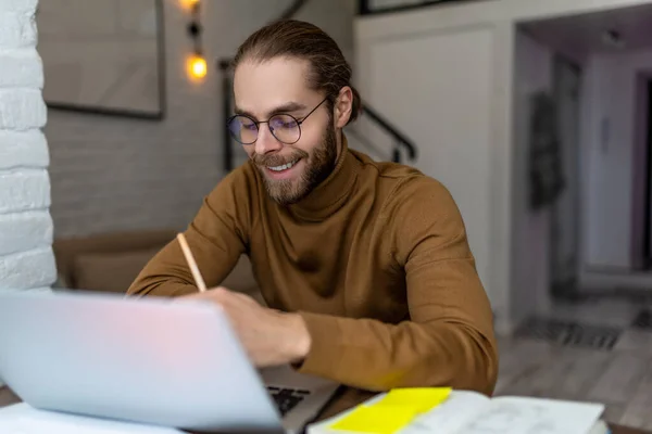 Hombre Sonriente Usando Ordenador Portátil Anotando Datos Importantes Cuaderno Trabajando —  Fotos de Stock