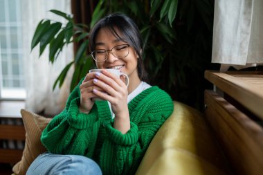 - Evde. Koyu saçlı genç kız evde sabah çayının tadını çıkarıyor.
