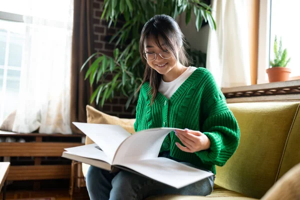 Lectura Joven Asiática Chica Con Gran Libro Sentado Sofá — Foto de Stock