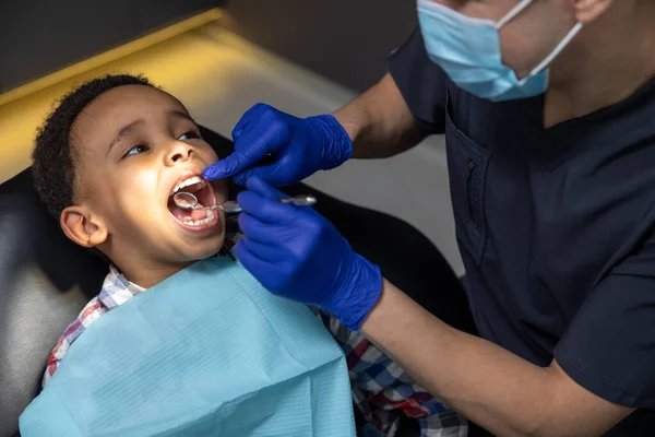 Dentista Menino Pele Escura Olhando Assustado Enquanto Médico Verificando Seus — Fotografia de Stock