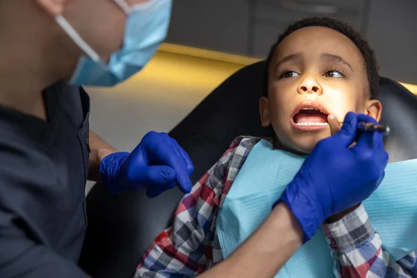 Odontología Niño Piel Oscura Mirando Asustado Mientras Médico Revisa Sus —  Fotos de Stock