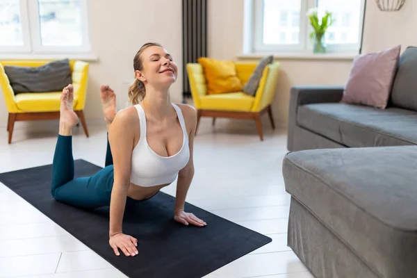 Spor Kıyafetli Genç Bir Kadın Içinde Egzersiz Minderinde Yoga Yapıyor — Stok fotoğraf