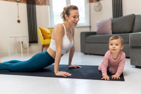Donna Atletica Alto Leggins Praticare Yoga Con Sua Bambina Soggiorno — Foto Stock