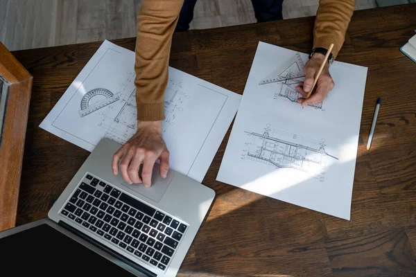 Nierozpoznawalny Architekt Szkicujący Projekt Budowlany Laptopem Rysunkami Rysunkowymi Miejscu Pracy — Zdjęcie stockowe