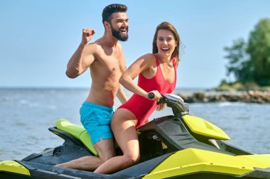 Güzel bir çift jet ski 'de oturmuş tatil köyünde balayının tadını çıkarıyorlar. Aktif zaman geçiriyorlar, su sporları yapıyorlar..