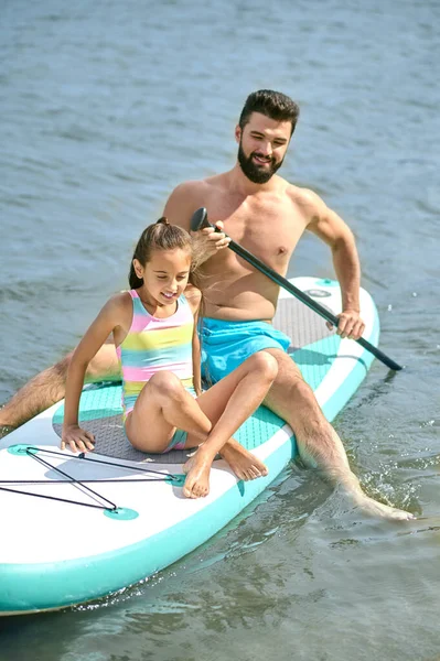 Homme Athlétique Avec Fille Assis Sur Planche Surf Dans Eau — Photo