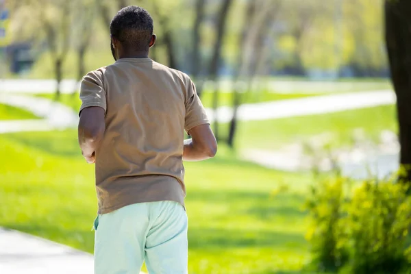 ジョギングだ 成熟したアフリカ系アメリカ人男性が公園でジョギングし コンテンツを見て — ストック写真