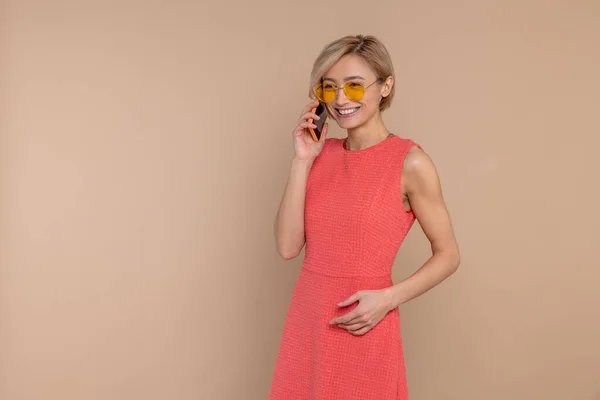Pleased Smiling Woman Dress Sunglasses Talking Cell Phone Isolated Beige — Stock Photo, Image