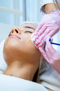 Genç bayan kozmetolojide cilt tedavisi, tanınmayan güzellik doktoru yüz yüze enjeksiyon yapıyor, prp ttherapy.