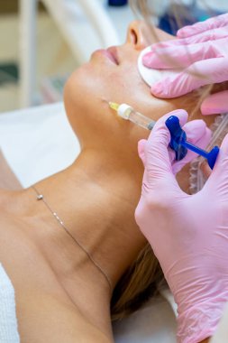 Güzellik kliniğinde PRP toterapisi, tanınmayan kozmetolojist kadınların yüzüne sorunlu deriyi tedavi etmek için kan plazması enjekte ediyor..