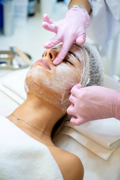 无法辨认的美容师医生在Prp治疗前在妇女脸上贴上麻醉药膏膜 — 图库照片