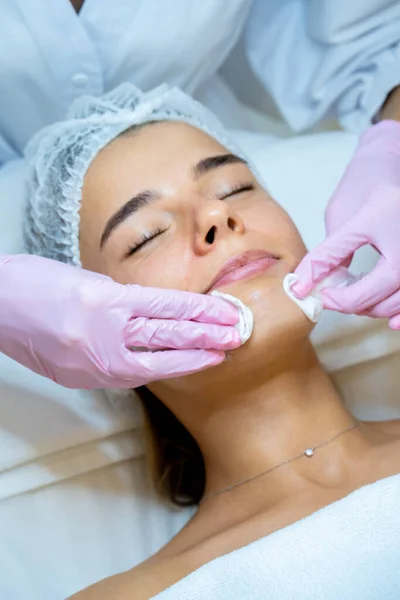 无法辨认的美容师医生用棉垫 皮肤护理程序 年轻化来清洁妇女的脸 — 图库照片