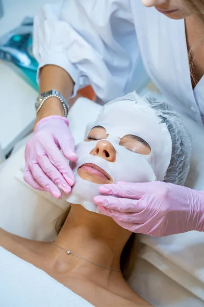 Cosmetologo Irriconoscibile Indossando Guanti Gomma Applicare Maschera Foglio Sul Viso — Foto Stock