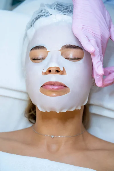Unrecognizable Cosmetologist Wearing Rubber Gloves Applying Sheet Mask Face Woman — Stock Photo, Image