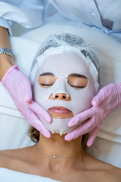 Unrecognizable Cosmetologist Wearing Rubber Gloves Applying Sheet Mask Face Woman — Stock Photo, Image