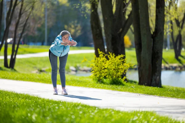 Γυμνάζομαι Γυναίκα Μπλε Σακάκι Κάνει Κλίσεις Στο Πάρκο — Φωτογραφία Αρχείου