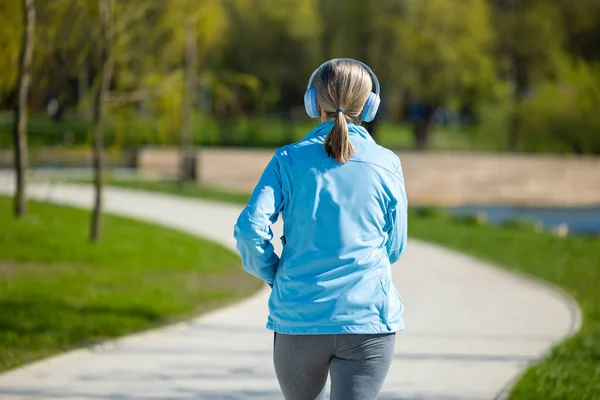 Jogging Žena Modrém Saku Poslouchá Hudbu Běhání — Stock fotografie
