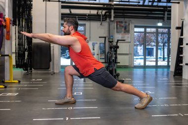 Sporcu adam spor salonu, vücut bakımı ve sağlıklı yaşam tarzından önce ısınıyor ve geriniyor..