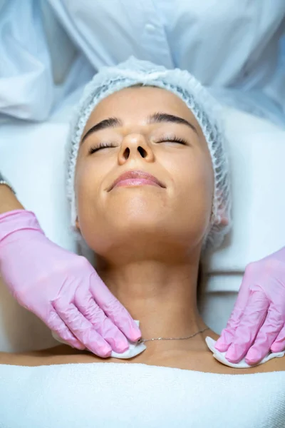 无法辨认的女性美容师医生清洁顾客的皮肤 给女性病人做面部按摩 — 图库照片