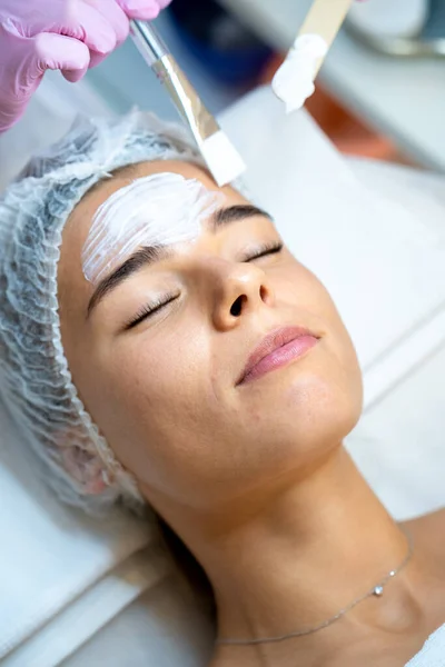 无法辨认的专业美容师为女性客户实施皮肤护理程序 — 图库照片