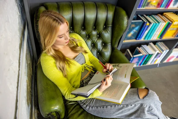 図書館で 若い女性が図書館でノートを作る — ストック写真