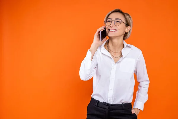 Lachende Vrouw Witte Officiële Stijl Shirt Praten Smartphone Geïsoleerd Oranje — Stockfoto