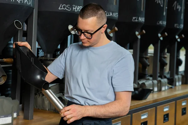 Pracownik Kawiarni Okularach Fartuchu Stojący Przy Ladzie Nalewając Ziarna Kawy — Zdjęcie stockowe