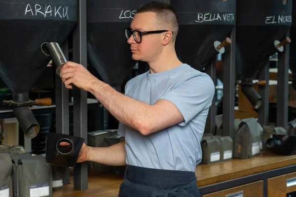 Pracownik Kawiarni Okularach Fartuchu Stojący Przy Ladzie Nalewając Ziarna Kawy — Zdjęcie stockowe