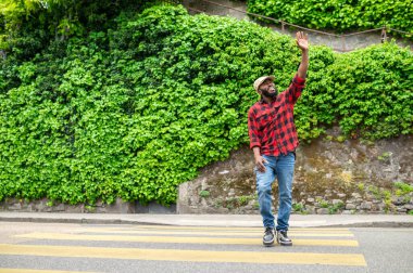 Sokaktaki adam. Yeşillik arka planda bir sokakta bir adam