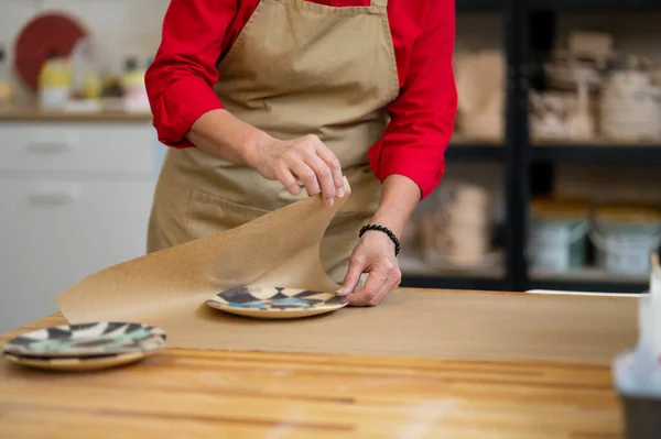 女陶大师的手在工作场所将客户订购的陶器包装成纸 — 图库照片