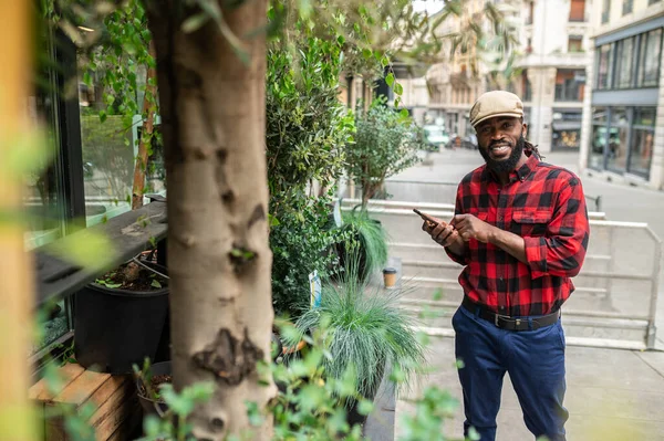 Yeşillik Sokakta Şapkalı Bir Adam Bitkilere Bakıyor — Stok fotoğraf